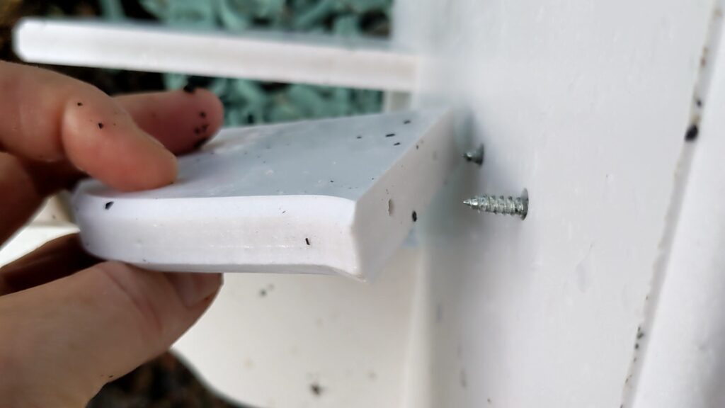 aligning screws in predrilled holes on birdhouse