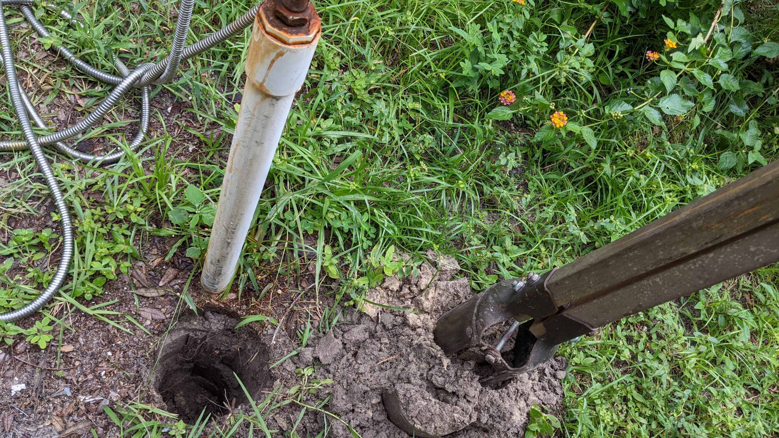 dug a hole with post hole digger near pvc water spigot