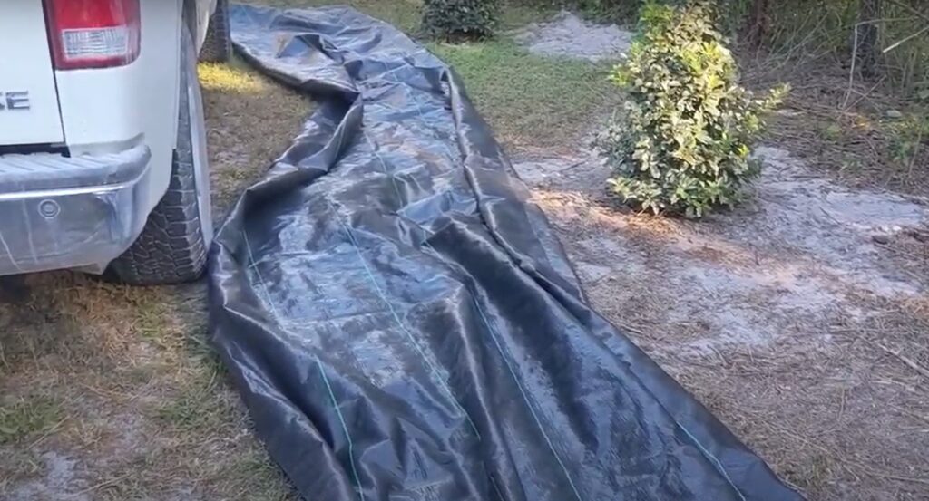 laying landscape Fabric next to oakleaf hollies